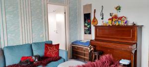 - un salon avec un canapé bleu et un piano dans l'établissement Capitano, à Lahti