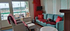 a living room with a blue couch and red pillows at Capitano in Lahti