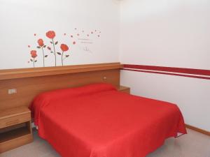 1 dormitorio con 1 cama con manta roja en Gemütliche Ferienwohnung in Cassone Di Malcesine mit Garten, en Malcesine