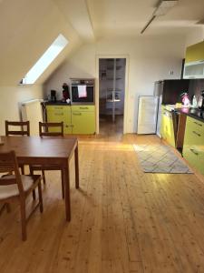 a kitchen with a wooden table and yellow cabinets at Brick House in Frohburg