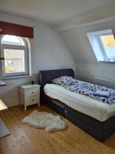 a bedroom with a bed and two windows and a rug at Brick House in Frohburg
