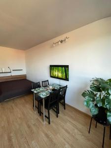 a dining room with a table and chairs and a tv at Apartment in Ljubljana center in Ljubljana