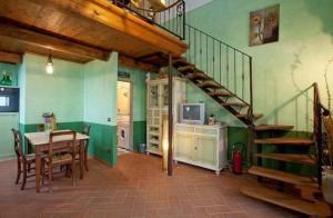 comedor con escalera y mesa con TV en Appartement in Vinci mit Terrasse, gemeinsamem Pool und Grill und Panoramablick, en Vinci