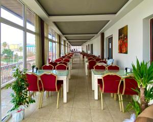 una fila di tavoli e sedie in una stanza con finestre di İpek Palas Otel a Şanlıurfa