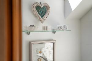 a mirror and a shelf with towels and a heart at Killoran House in Dervaig