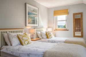 a bedroom with two beds and a window at Killoran House in Dervaig