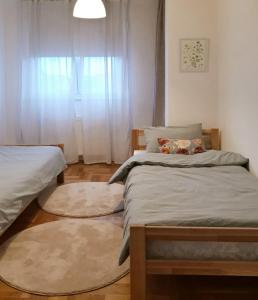 um quarto com 2 camas individuais e uma janela em Sunshine Apartment em Bijeljina