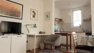 a kitchen with a desk and a television and a table at Sunshine Apartment in Bijeljina