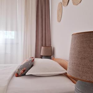 um quarto com uma cama com uma almofada e uma janela em Sunshine Apartment em Bijeljina