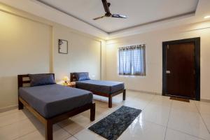 a bedroom with a bed and a chair and a door at Wandr Scorpious - Manyata tech park in Bangalore