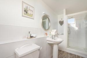 a white bathroom with a sink and a toilet at Killoran House in Dervaig