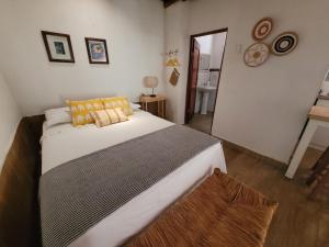 ein Schlafzimmer mit einem großen weißen Bett mit orangefarbenen Kissen in der Unterkunft Casa Huerta in Chincha Alta