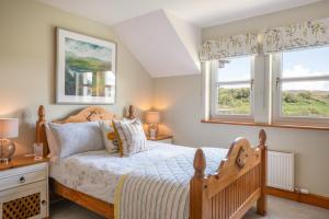 a bedroom with a bed and two windows at Killoran House in Dervaig