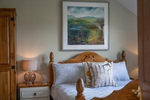 a bedroom with a bed with a picture on the wall at Killoran House in Dervaig