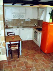 een keuken met een tafel en een rode koelkast bij Casa Roberto - Campagna Toscana vicino al mare in Castellina Marittima