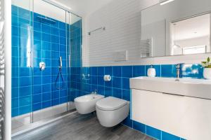 Baño de azulejos azules con aseo y lavamanos en Casa Ersilia, en Meta