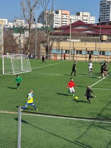 a group of children playing soccer on a field at Renthouse Apartments City Gates #5 in Chişinău