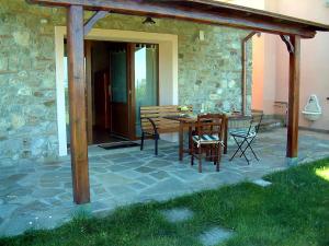 een patio met een houten tafel en stoelen bij Casa Roberto - Campagna Toscana vicino al mare in Castellina Marittima