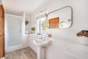 a white bathroom with a sink and a mirror at Killoran House in Dervaig