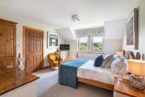 a bedroom with a bed and a desk in it at Killoran House in Dervaig