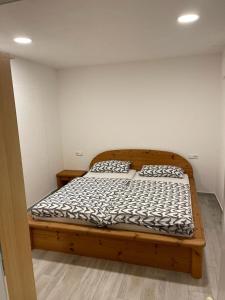 un lit en bois dans une chambre avec deux oreillers dessus dans l'établissement Ferienwohnung City Priebe Austraße, à Friedrichshafen