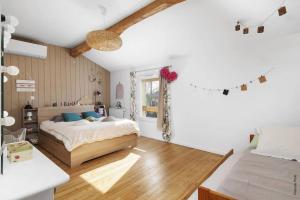 a bedroom with a bed and a window at Logement familial « Le Ribet » in Saint-Étienne-de-Tulmont
