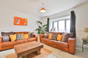 uma sala de estar com um sofá de couro e uma mesa em May Disc - Long Stay - Contractors em Bath