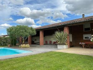 a house with a swimming pool in the yard at Logement familial « Le Ribet » in Saint-Étienne-de-Tulmont