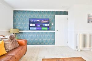 uma sala de estar com um sofá e uma televisão de ecrã plano em May Disc - Long Stay - Contractors em Bath