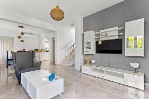 a living room with a tv and a couch and a table at Villa Santa Marina in Spetses