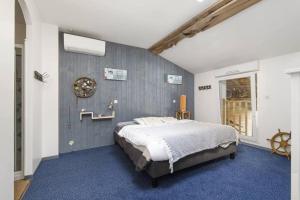 a bedroom with a bed and a blue carpet at Logement familial « Le Ribet » in Saint-Étienne-de-Tulmont +17 photos