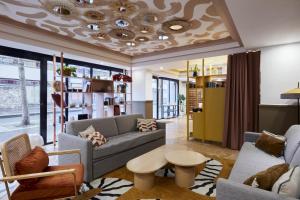 a living room with a couch and a table at Aparthotel Adagio Paris Buttes Chaumont in Paris