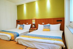 BudaiにあるThe Wind B&Bの黄色い壁の客室内のベッド2台