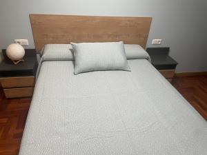 una camera da letto con un letto con un cuscino sopra di Sweet Home a Moaña