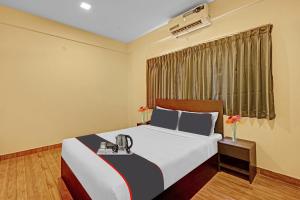 Super OYO Manyata Stay-In في بانغالور: غرفه فندقيه بسرير ونافذه