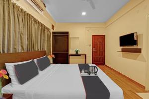 Super OYO Manyata Stay-In في بانغالور: غرفة نوم بسرير كبير وتلفزيون