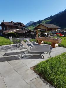un gruppo di sedie e una panchina su un patio di BnB Fellacher ad Adelboden