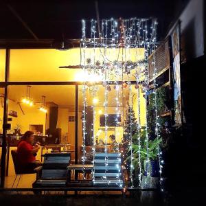 a room with a christmas tree and a chandelier at Three Hostel at Night Market Pakchong in Ban Sao Thong