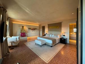 duża sypialnia z łóżkiem i krzesłem w obiekcie Hotel Palazzo Durazzo Suites w Genui