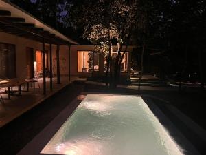 a pool of water at night in a backyard at Saraca Resort & Spa Corbett in Garjia