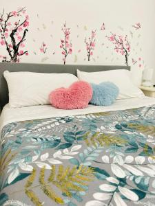 - 2 oreillers sur un lit avec des fleurs sur le mur dans l'établissement Da Mauro & Michela a Tor Vergata, à Rome