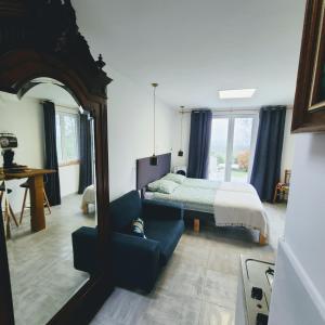 a bedroom with a bed and a mirror and a couch at Studio L'audrerie. in Saint-Pardoux-Corbier