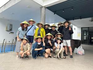 a group of children wearing hats posing for a picture at Luxury Beach Villa Da Nang in Danang