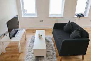 uma sala de estar com um sofá preto e uma mesa branca em Peaceful 2 Bed Townhouse, Close to City Centre em Reading