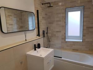 bagno con lavandino, vasca e specchio di Peaceful 2 Bed Townhouse, Close to City Centre a Reading