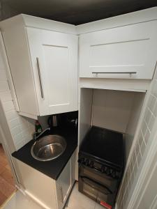 a small kitchen with white cabinets and a sink at Delightful 3 Bed Dublin City House in Dublin