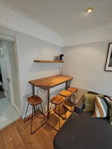 a living room with a table and stools and a couch at Delightful 3 Bed Dublin City House in Dublin
