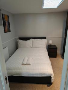 a white bed with a pair of slippers on it at Delightful 3 Bed Dublin City House in Dublin