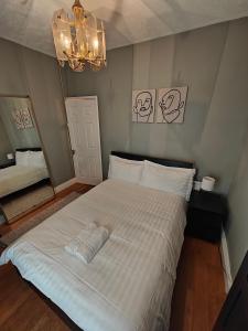 um quarto com uma grande cama branca e um lustre em Delightful 3 Bed Dublin City House em Dublin