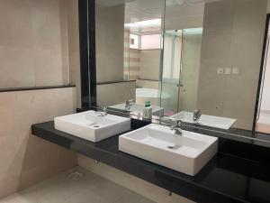 un bagno con due lavandini e un grande specchio di Royal Nest Premium-AS a Pune